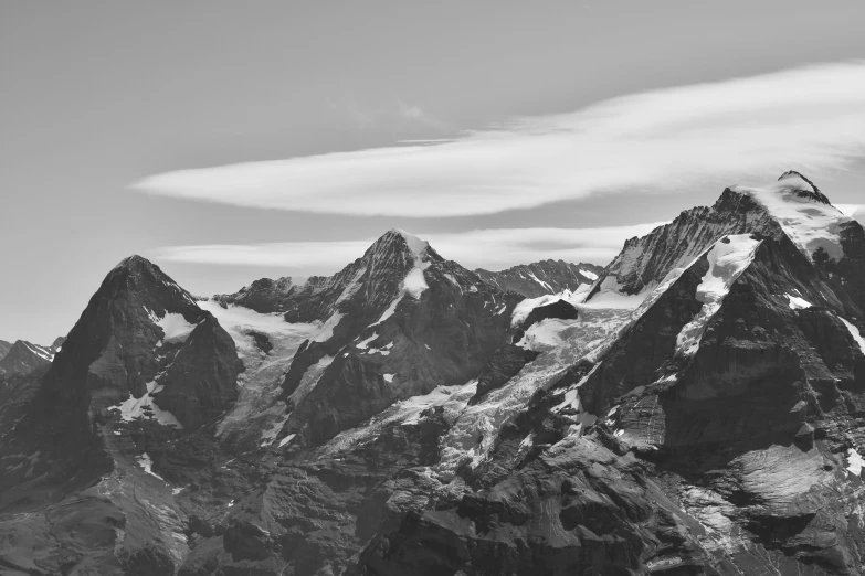 black and white image of snowy mountains with clouds in the background