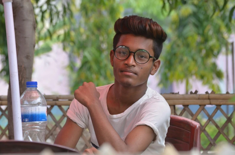 a person sitting at a table with a bottled water bottle