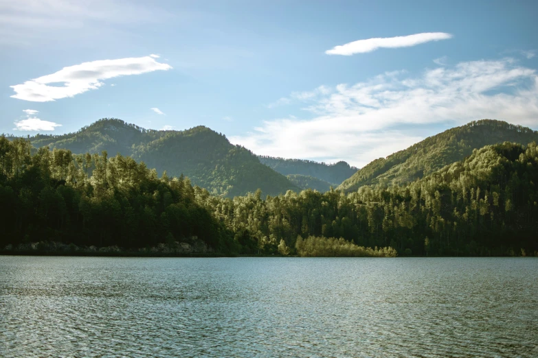 a mountain range on a calm lake with clear blue water