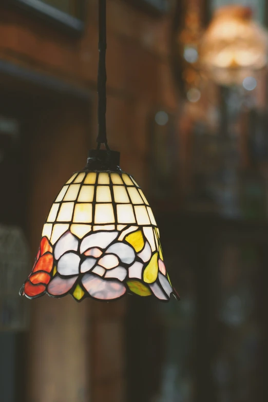 a large colorful glass hanging from a black hook