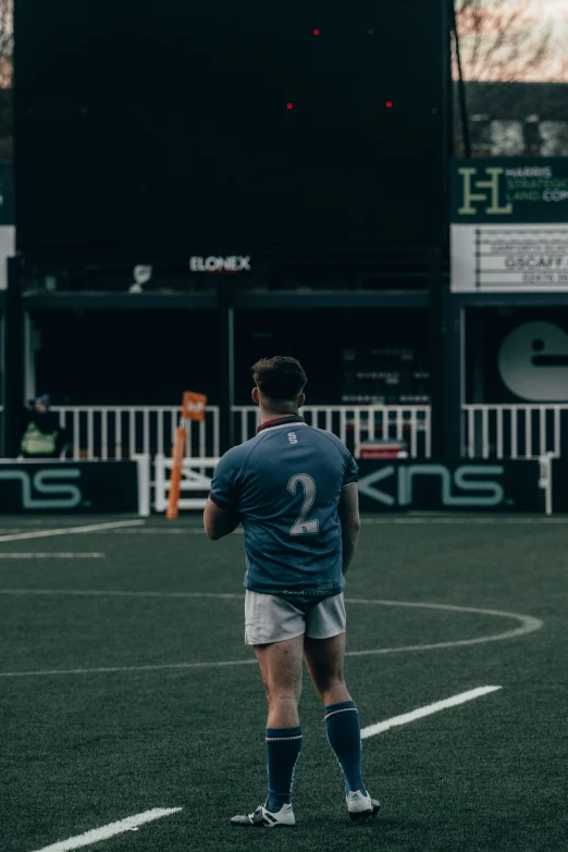 a man standing on the field looking at a soccer ball