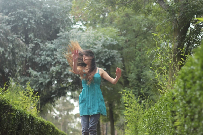 girl standing in the road holding soing in front of her face