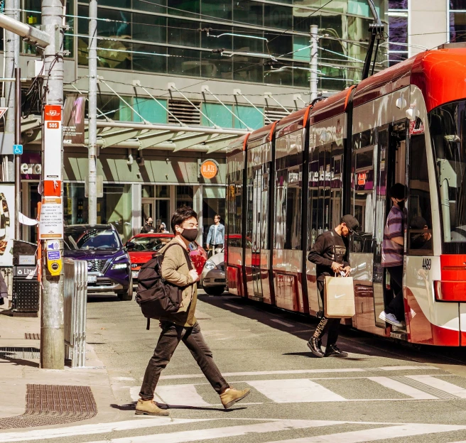 people are crossing the street with their buses