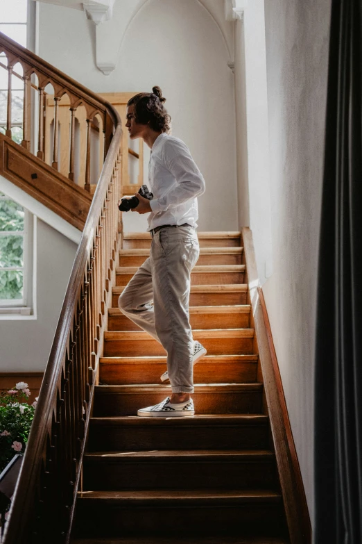 the young man is standing on the stairs looking down