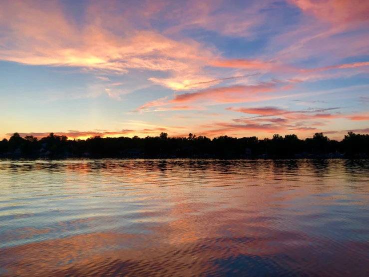 the sunset reflected on the water of a lake