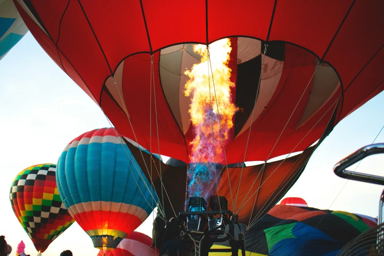 several  air balloons being turned on by a crowd