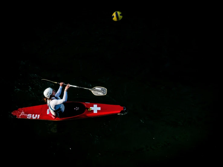 a man on a kayak with a swiss flag