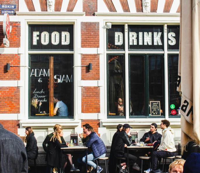 a city sidewalk filled with people and tables