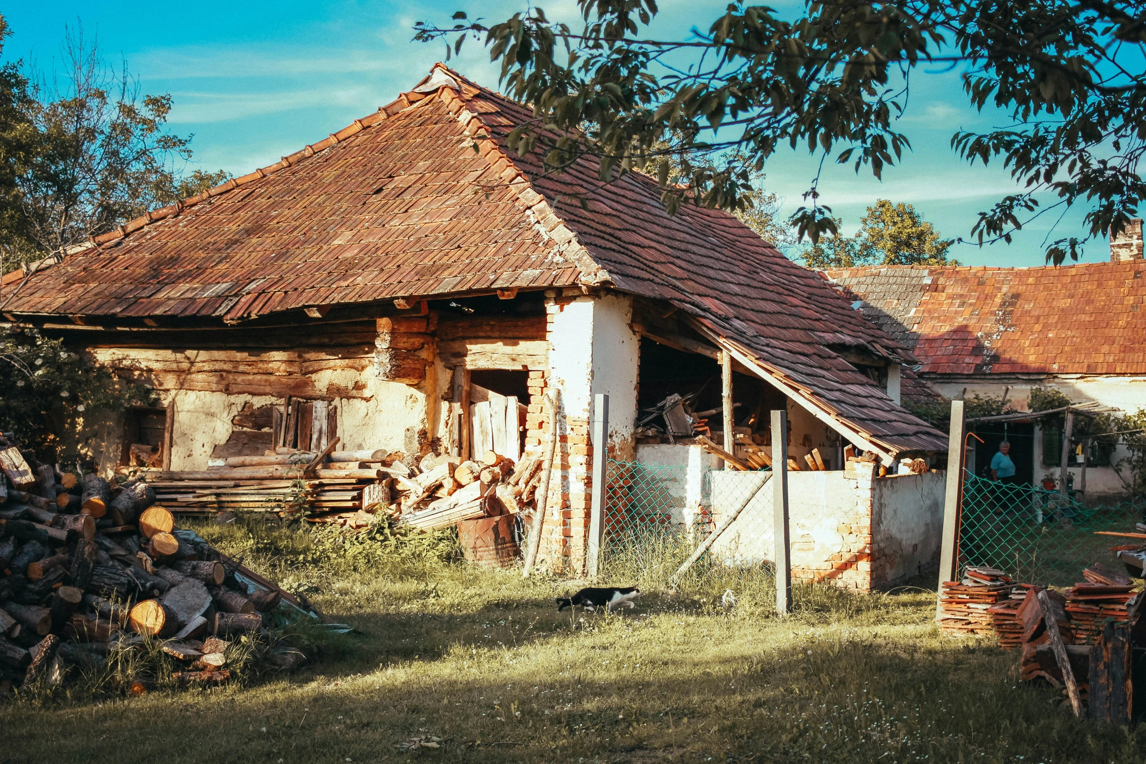 an old building with wooden logs near trees