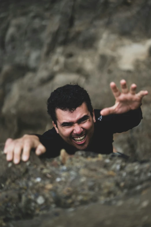 a man is in the rocks reaching out for his own hand