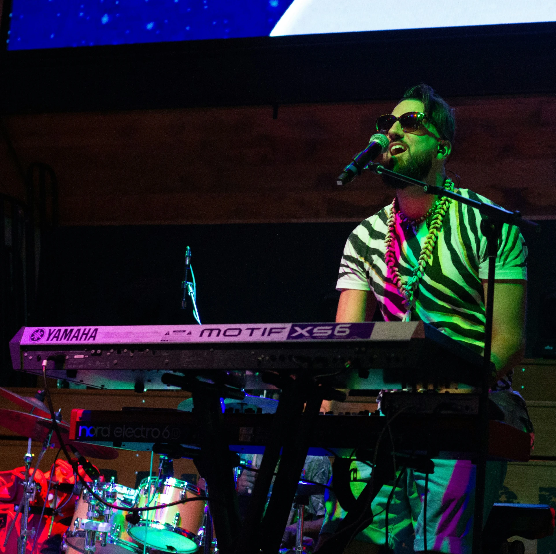 a man with glasses on a keyboard playing an instrument