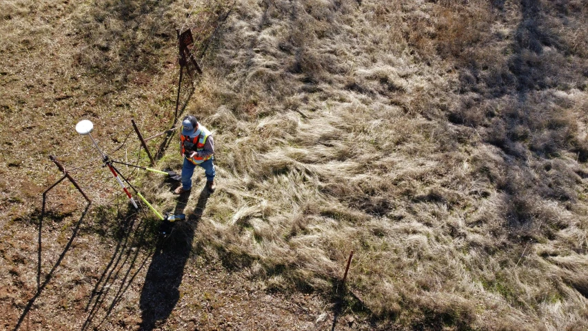 a man working in a field by some trees