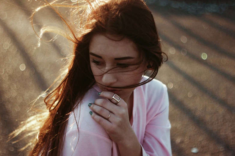 the young woman is posing with her hair in her hand