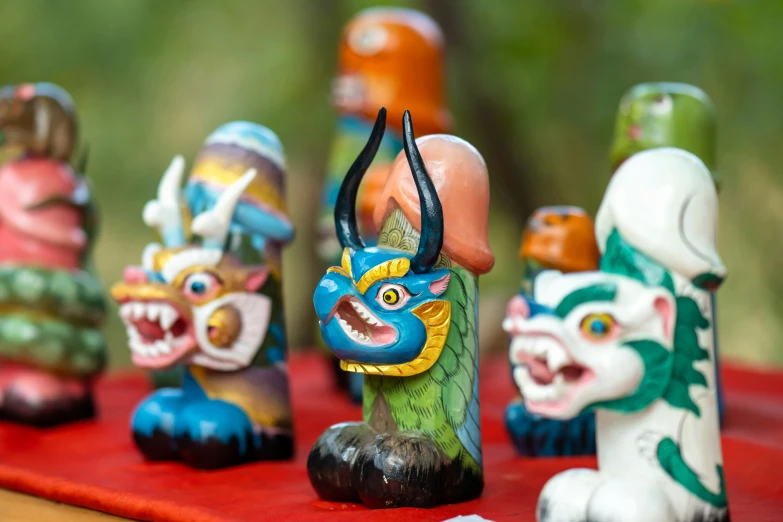 several ceramic dolls sitting on a red surface