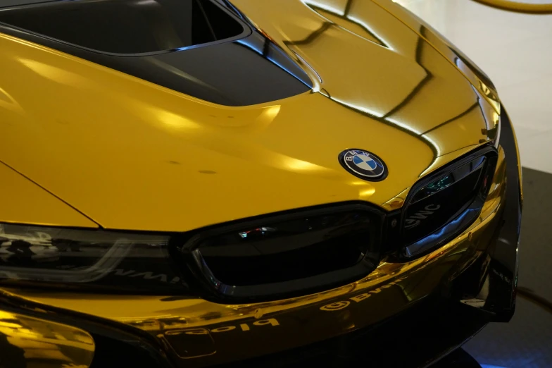 a shiny yellow car has a black strip on it