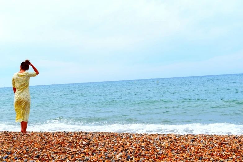 a woman in a yellow dress is on the beach