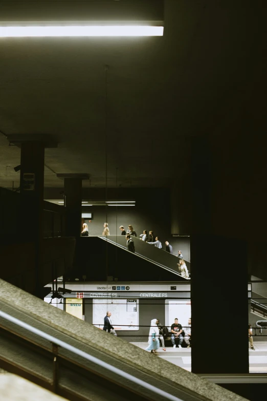 some people on the street and escalator in the building