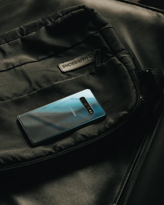 a blue cellphone on an black jacket pocket