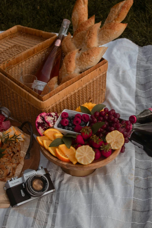 fruit in baskets are displayed with bread sticks and champagne