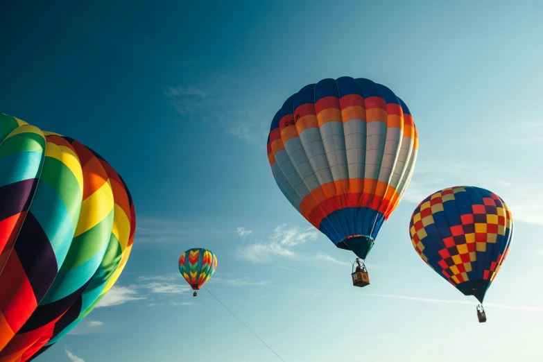 multi - colored  air balloons flying across a blue sky