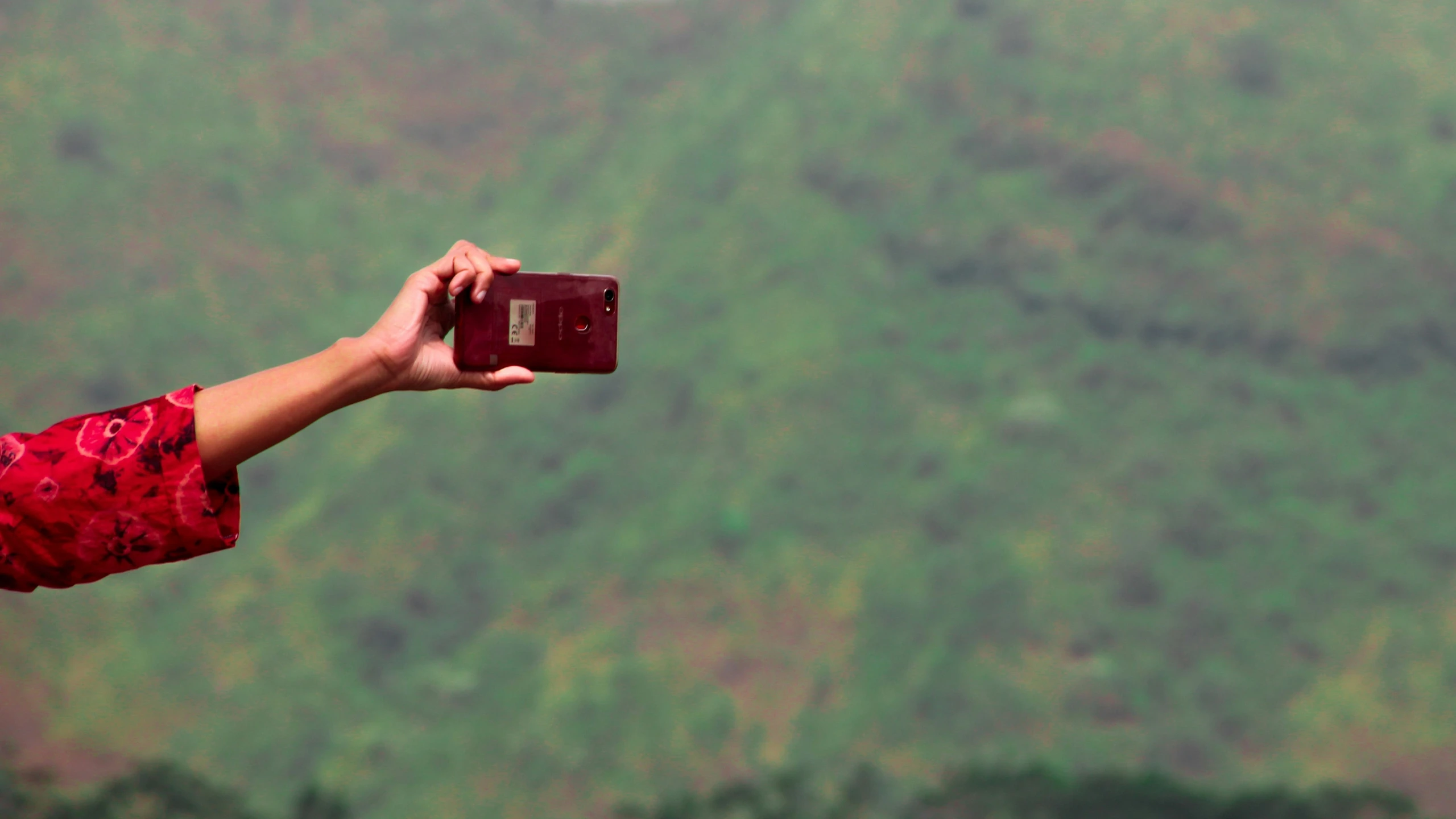 a man taking a po with a camera and pointing it at the landscape