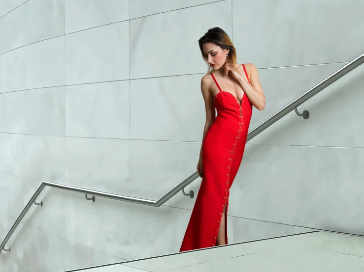 a woman standing on a stair railing near stairs