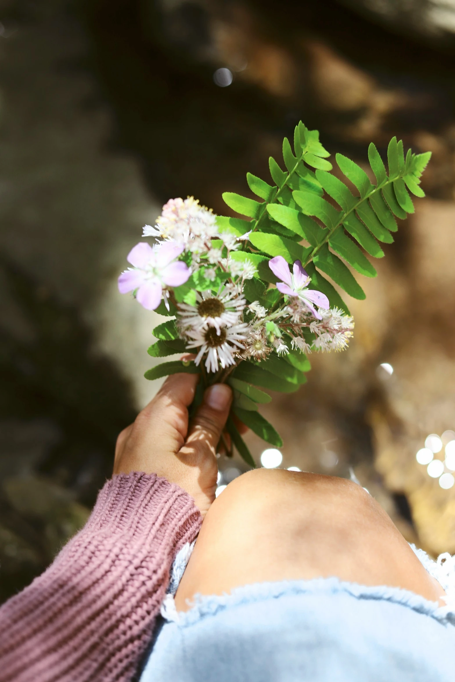 the person is holding a bunch of flowers in their hand