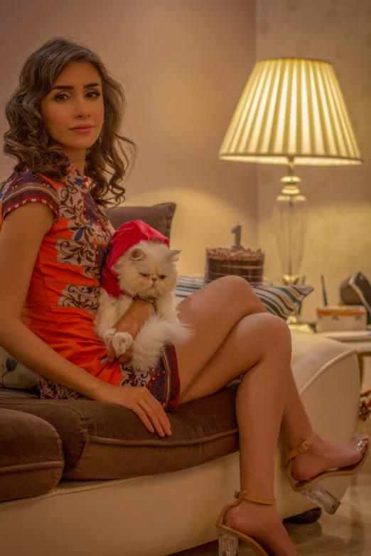 a woman sitting on top of a couch holding a white dog