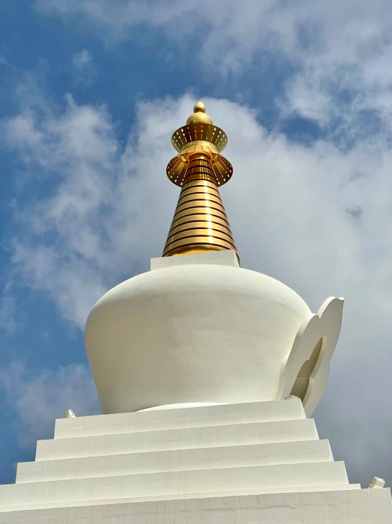 this gold bell sits atop the white structure