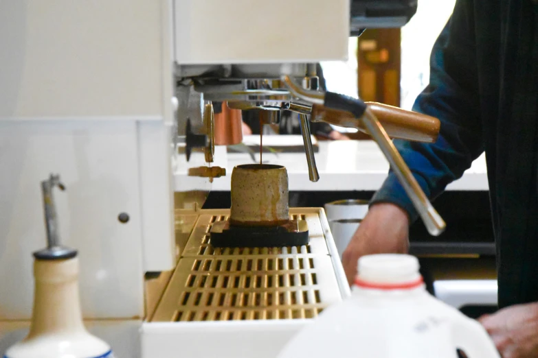 someone preparing drinks at an latte machine