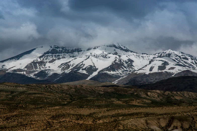 the snowy mountains are covered by clouds and dirt