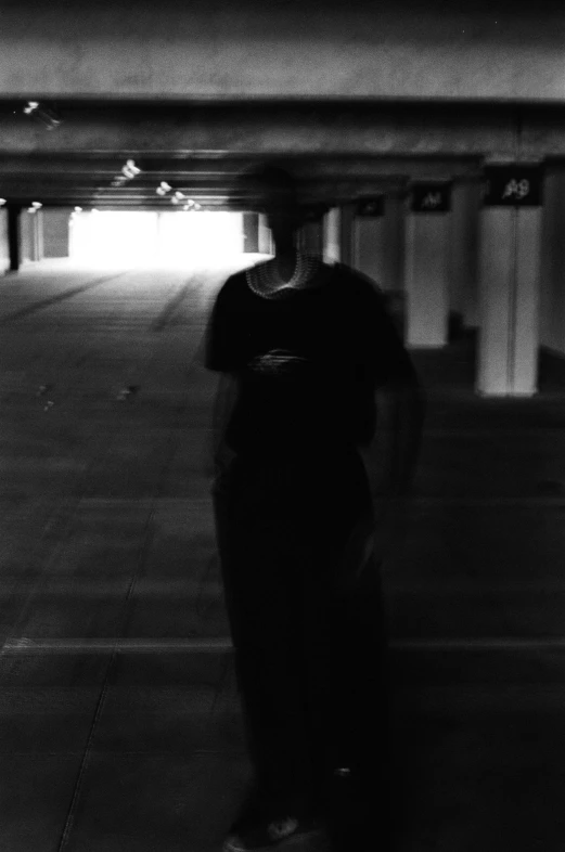 a black and white po of a person standing in a parking lot