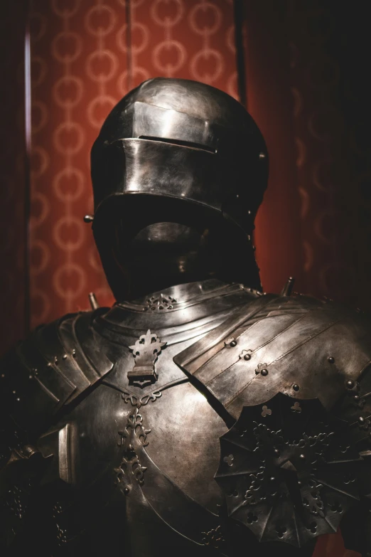 a man in armor stands with his hand on his hip