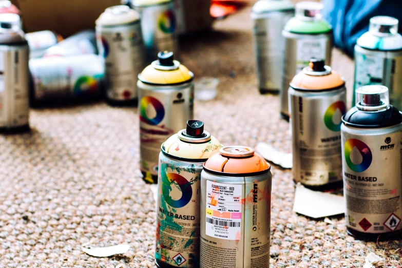 several cans of paint sitting on the ground