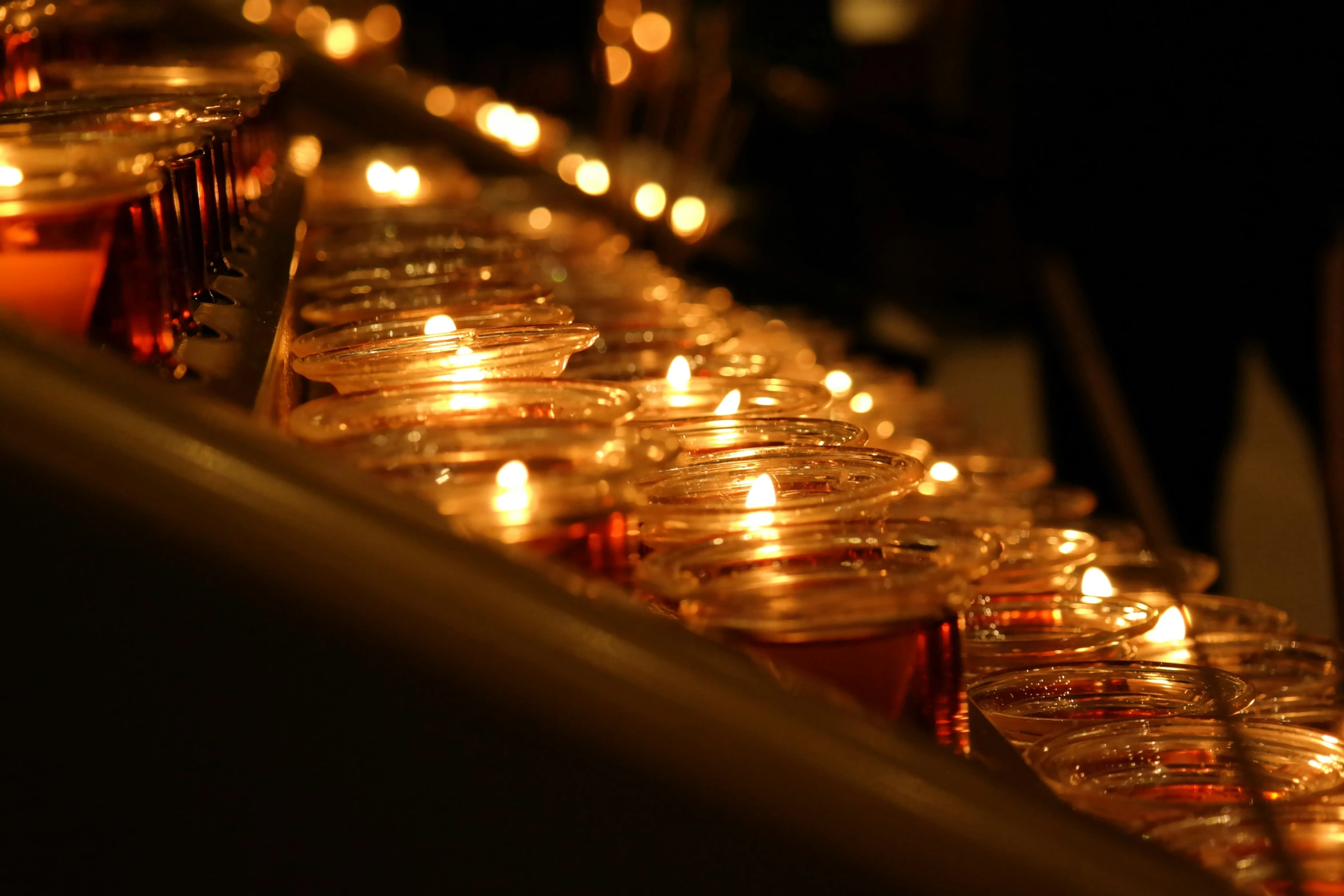 a bunch of glass candles lined up on the floor