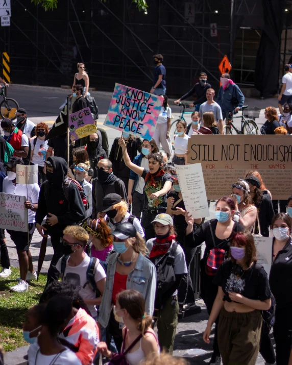 people hold signs as they protest on a city street