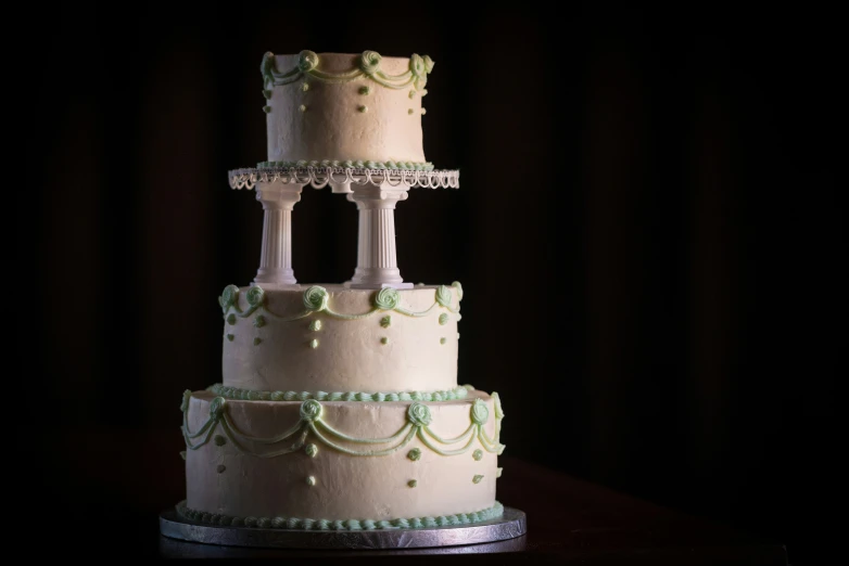 three tiered cake with white and blue frosting