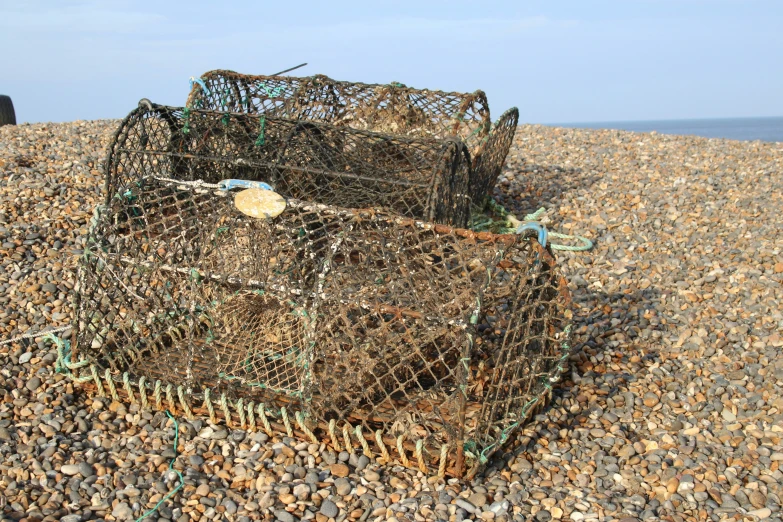 a set of crab traps with fish traps piled up on the beach