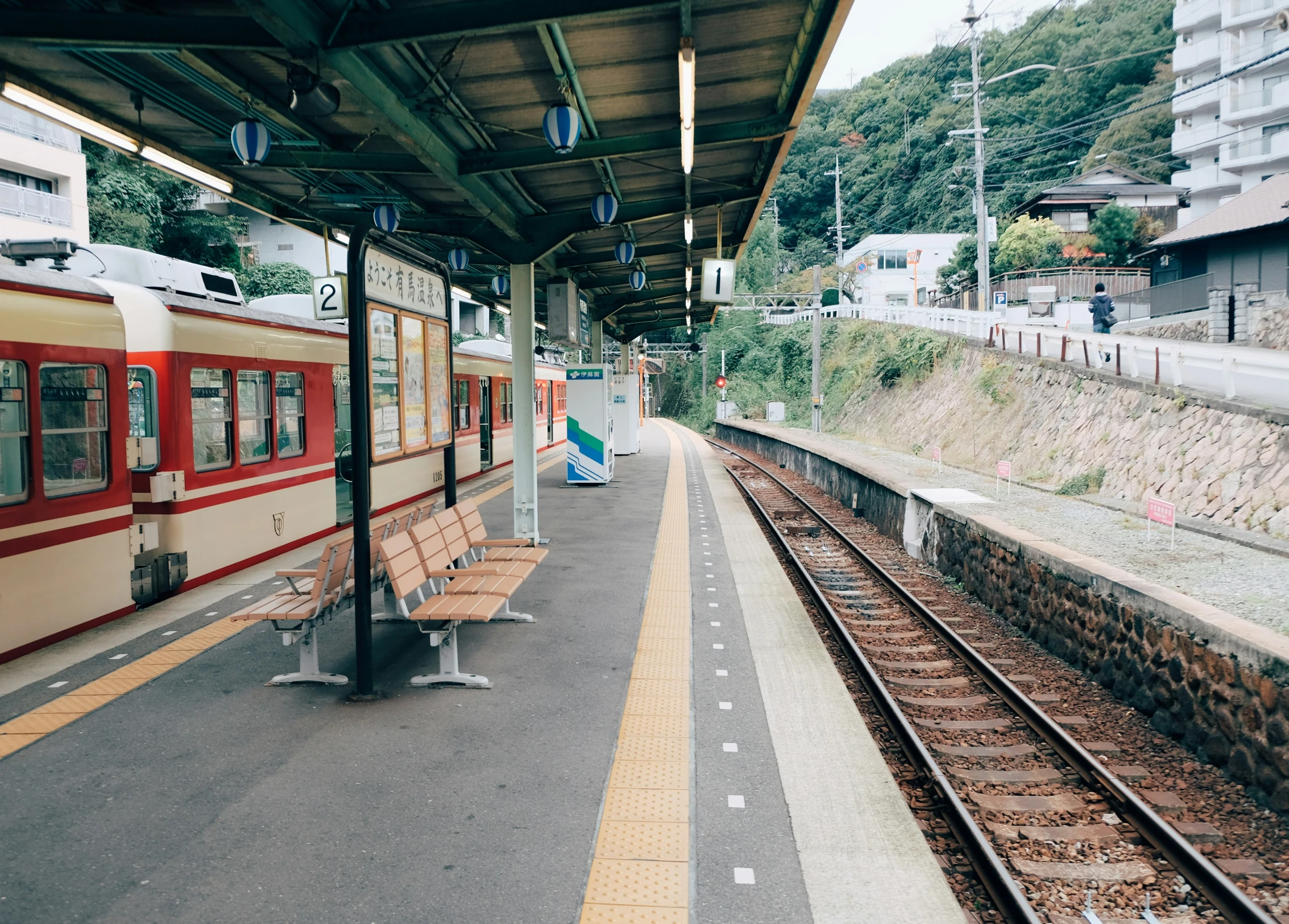 a train station with a bench next to it and other trains