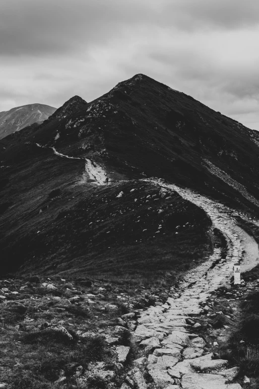 an unpaved road winding up to a rocky mountain