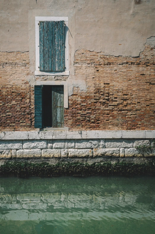 the water is green and small next to a building