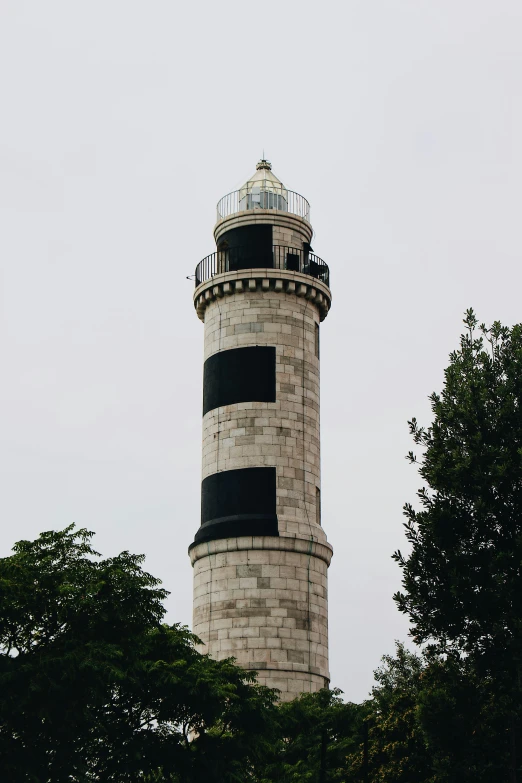 a small black and white tower with a clock on it