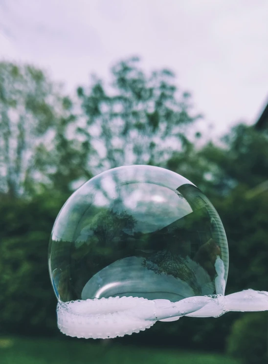 soap bubbles hanging from an outdoor hand rail