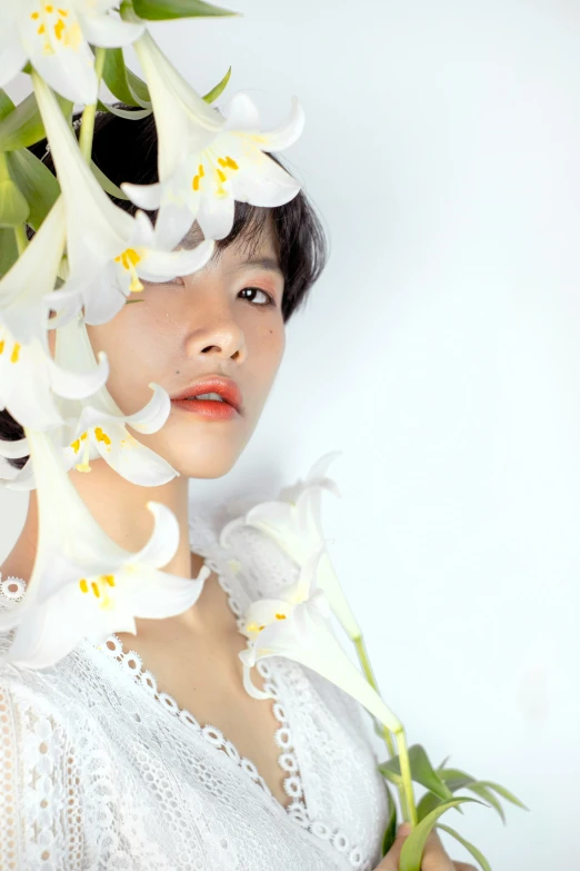 a woman wearing a white lace shirt with large flowers around her head