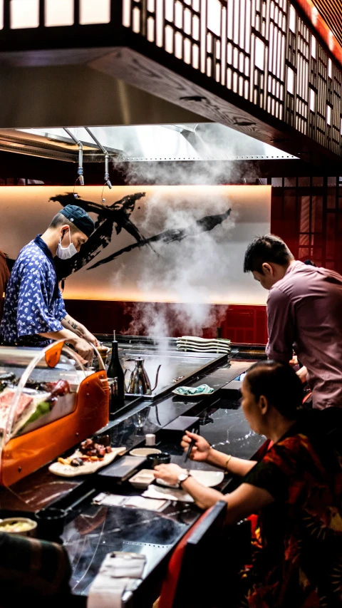 men preparing food on metal plates inside a restaurant