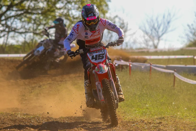 a dirt bike rider on a red bike in front of a motorcycle