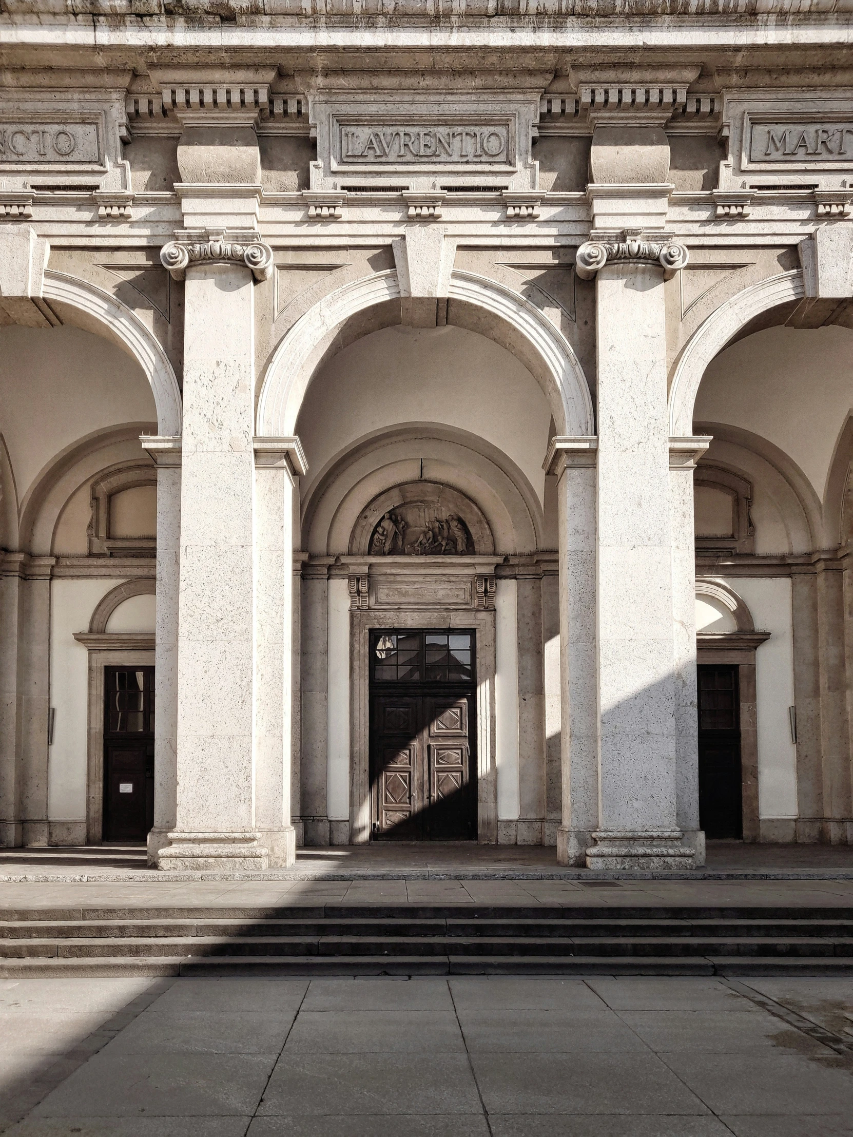 a building with stone arches and columns surrounding the doorway