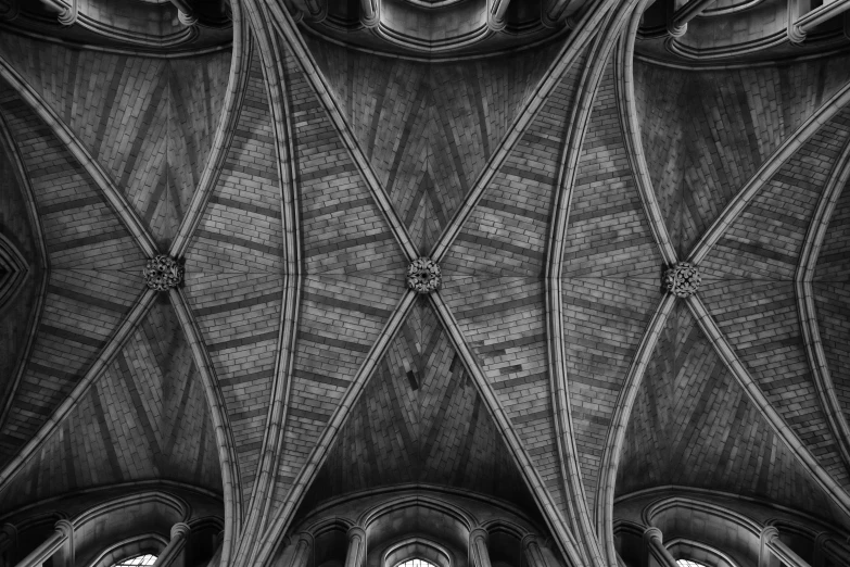 looking up into an intricate architecture piece, the roof beams and stained glass windows