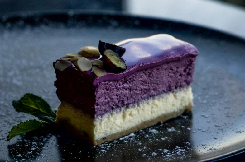 a piece of cake with a purple and white frosting sitting on a metal plate