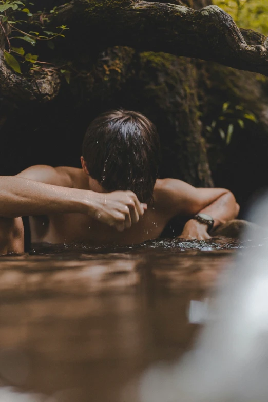 man relaxing on his chest in the water at a cave